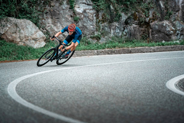 fahrradrennfahrer auf asphaltstraße kurve - bicycle sport cyclist mountain stock-fotos und bilder