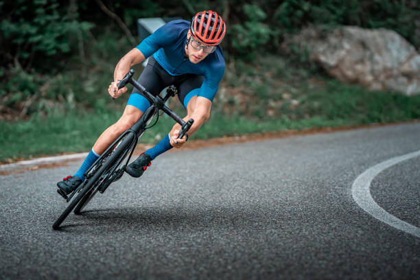 istock Bicycle racing cyclist on asphalt road curve 1256301375