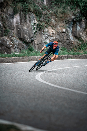 Bicycle racing cyclist on asphalt road curve