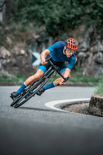 Bicycle racing cyclist on asphalt road curve