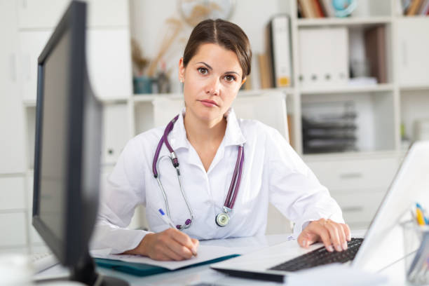 istock Smiling woman doctor working effectively in office 1256302383