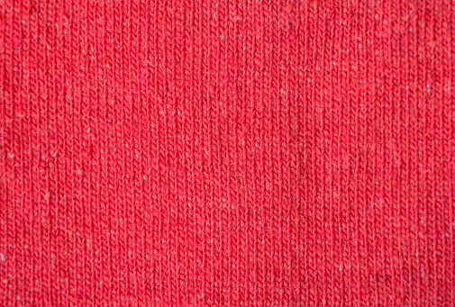 Bright red woven woolen background. Fabric for warm winter clothes.