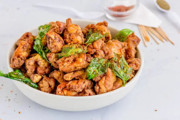 Taiwanese Fried Chicken in a Bowl with Basil Leaves and Seasonings