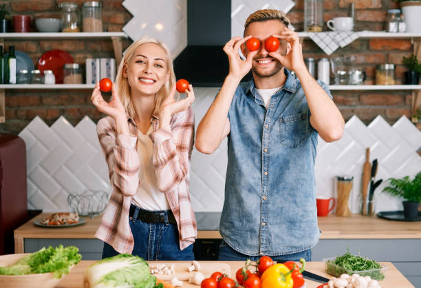 istock Happy smiling couple having fun cooking together in kitchen 1256303232