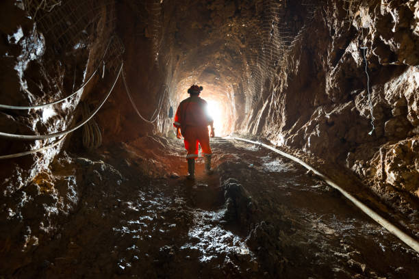 Miner inside the access tunnel of an underground gold and copper mine. stock photo