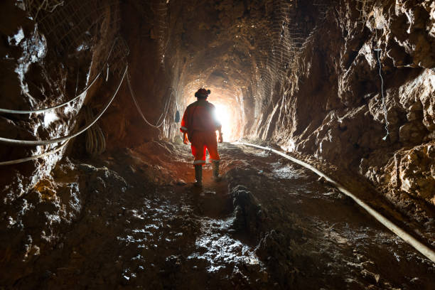 Miner inside the access tunnel of an underground gold and copper mine. Region del Maule, Chile - April 02, 2016: Miner inside the access tunnel of an underground gold and copper mine. copper mining stock pictures, royalty-free photos & images