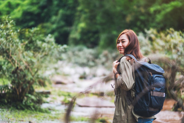 istock A female traveler with backpack walking  by mountain stream 1256309249
