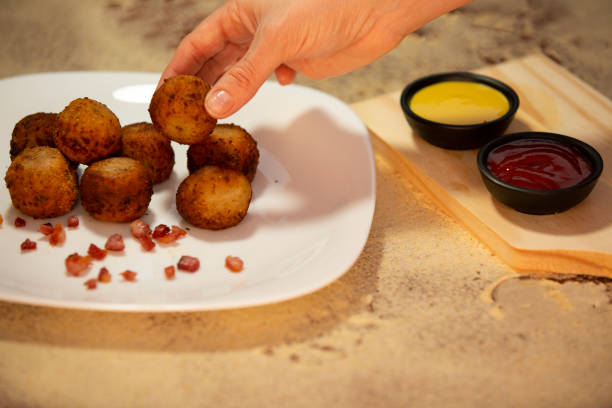 Cheese balls with bacon or croquettes made in breadcrumbs with ketchup and mustard. stock photo