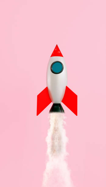 istock Small space ship launches and flys up in the air on pink background 1256311337