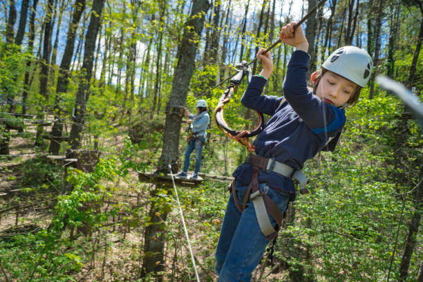Boy overcomes obstacles in Adventure Rope Park Boy overcomes obstacles in Adventure Rope Park baby gun stock pictures, royalty-free photos & images