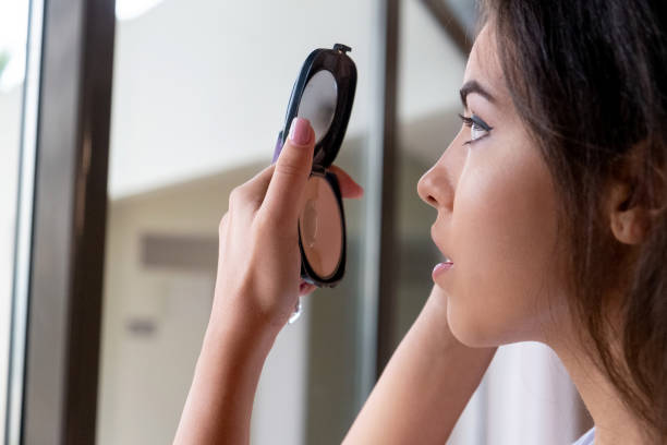 Face painting. Makeup artist applying shadows to model eye. Cosmetic beauty procedures, make up stage.