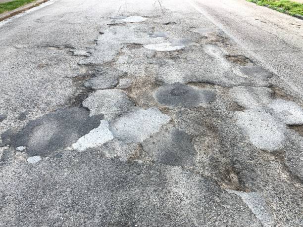 istock Patched Asphalt Road Potholes 1256313350