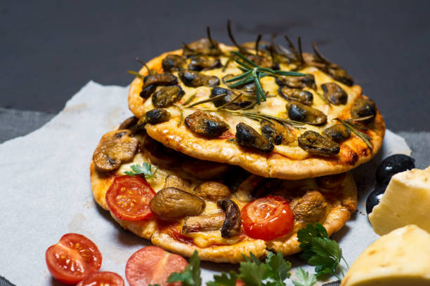 istock Homemade pizzas with seafood tomatoes and cheese on a dark table 1256314234