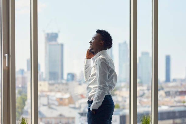 istock African ethnicity businessman making a call. City panorama 1256315904