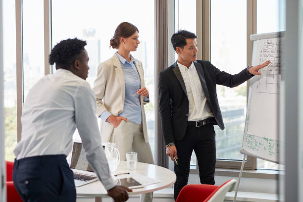 istock New normal. Diverse group of businesspeople analyzing data in the office 1256316890