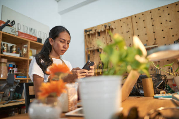 istock Asian woman carpenter using smart phone at her studio workshop 1256317427