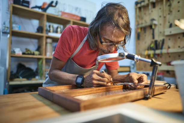 istock Asian male carpenter doing detailing work at his studio workshop 1256317673