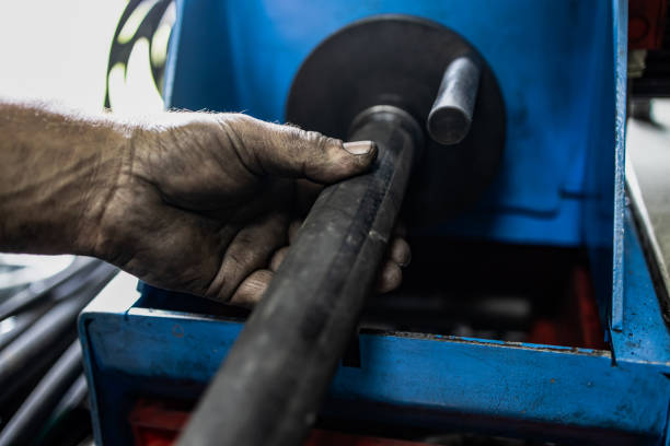 istock Worker, cutting hydraulic hoses in a metal workshop 1256318674