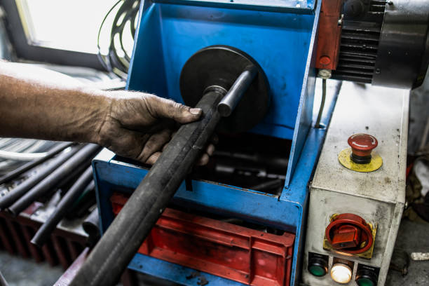 Worker, cutting hydraulic hoses in a metal workshop Worker, cutting hydraulic hoses in a metal workshop hydraulic hose stock pictures, royalty-free photos & images