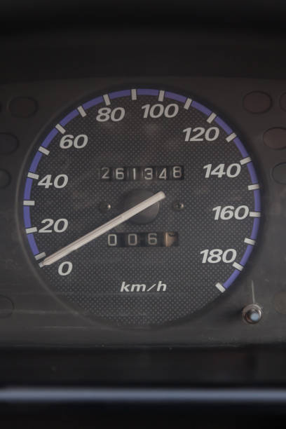 istock Close-up of a dashboard display sensor, on-board computer, speedometer with a blue line around the dial and white symbols on a dark background, which measures the speed of the car. 1256318712