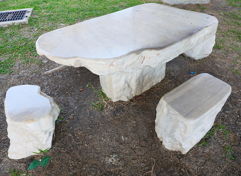 Natural stone table set in green garden park