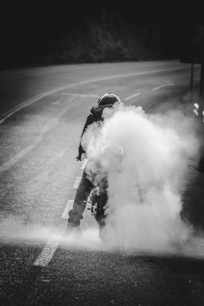 un hombre está quemando su neumático de moto - motorcycle engine brake wheel fotografías e imágenes de stock