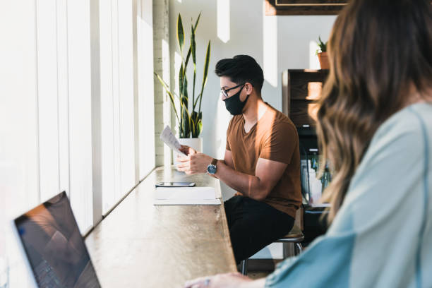istock Colleagues work together wearing protective masks and social distancing 1256321411