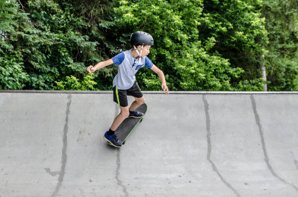 istock Young boy going up on ramp with skateboard 1256322941