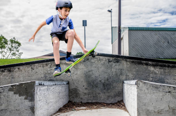 istock Young boy jumping between two ramps with skateboard 1256323754