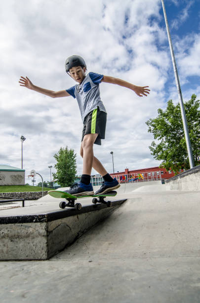 istock Young boy sliding on edge of step with skateboard 1256324215