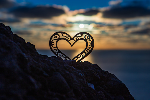 Heart on the background of the sunset sky and sea. Love and romance