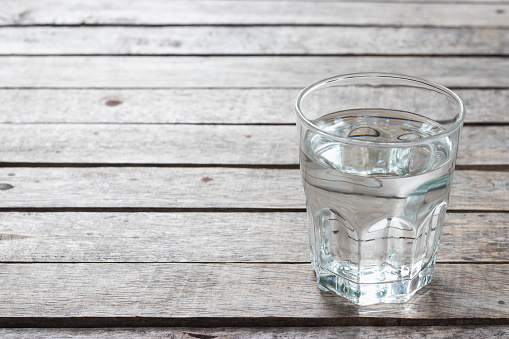 Fresh water in the glass on wooden table.