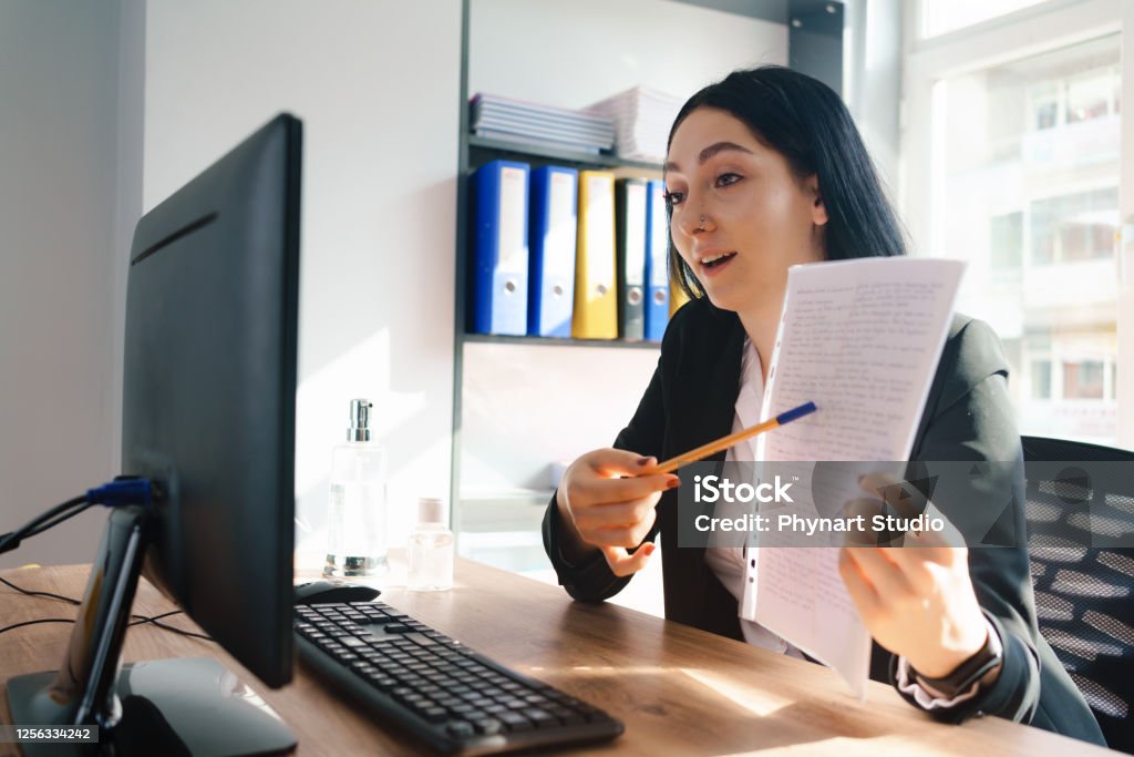 Happy executive pointing contract on videocall at office Lawyer Stock Photo