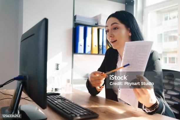 Happy Executive Pointing Contract On Videocall At Office Stock Photo - Download Image Now
