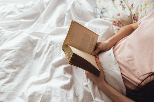 istock Woman holds open book in hands. Home reading concept 1256337730