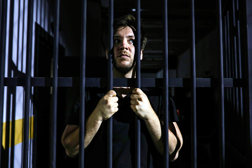 Young Man Behind Bars in Prison