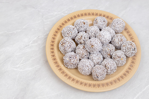 Energy Balls cookies with grated coconut served on the plate.