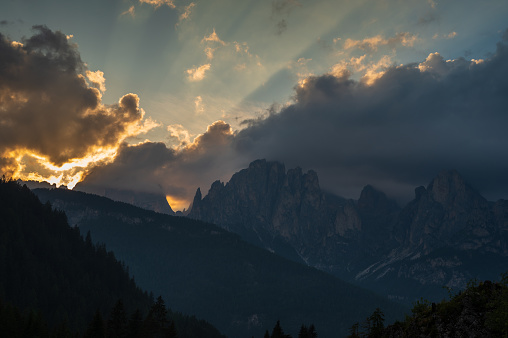 view of a sunset over Mount Catinaccio, (Rosengarten) during a cloudy evening by Pozza di Fassa, Dolomites, Italy