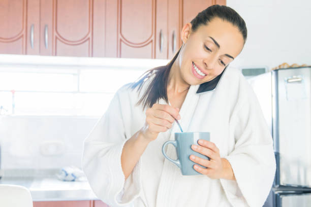 istock Woman talking on the phone while drinking coffee in the morning 1256347051
