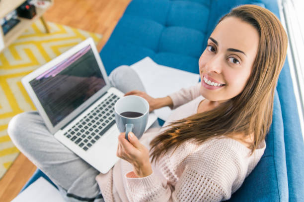 istock Young woman studying online at home and drinking coffee 1256347122