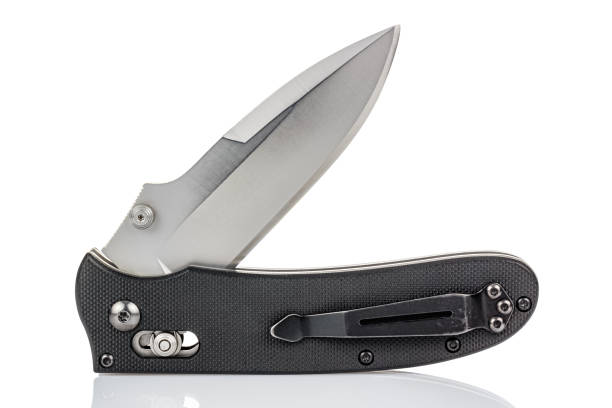 Open folding pocket knife with satin blade and textured black composite plastic cover plates on steel handle isolated on white background with reflection on glossy surface. Pocket knife close-up image