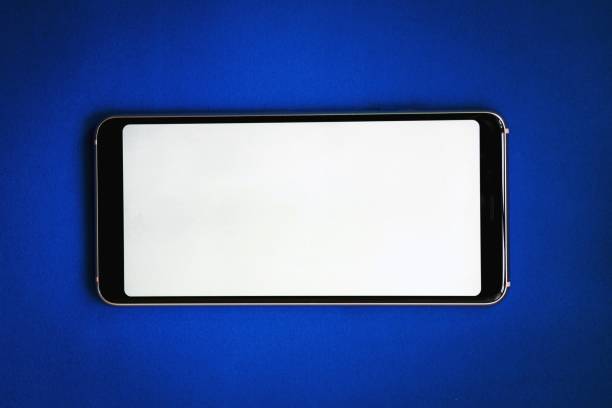 istock Black smartphone with a white blank screen on a blue background. Horizontal orientation, copy space 1256348313