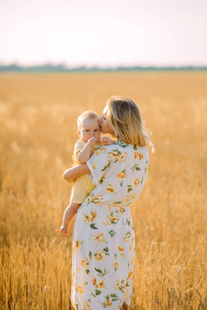 istock Mother walks with her baby among wheat field. 1256353326