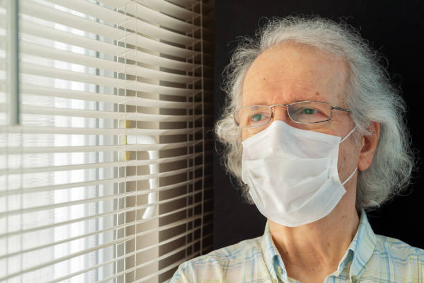 istock Senior Man Wearing Surgical Mask 1256353415
