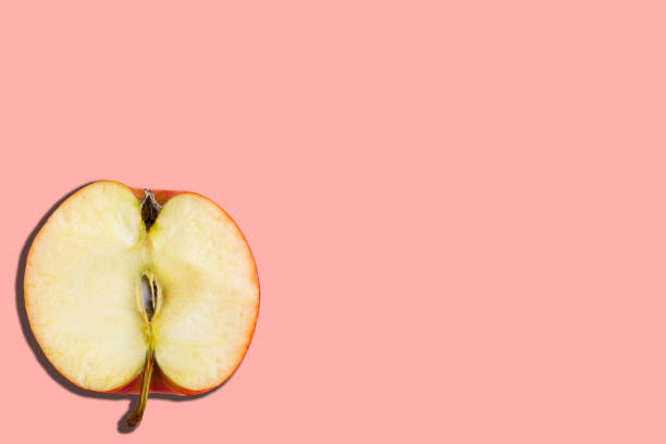 istock Sliced red apple on pastel pink background, minimal concept, copy space, banner 1256354869