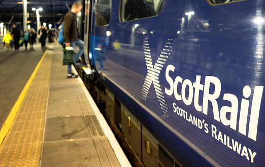 Glasgow, Scotland - Passengers on the platform at Queen Street Station in central Glasgow, with a man boarding a Scotrail train.