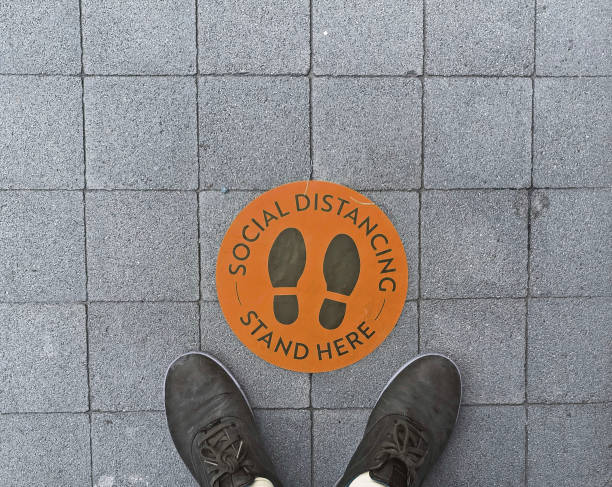 istock Social Distancing Circular, Orange Floor Sticker with Feet 1256361361