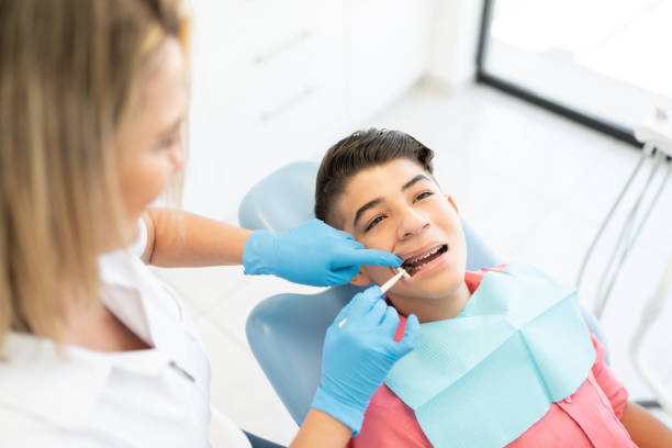 istock Orthodontist Examining Boy With Dental Mirror 1256361581
