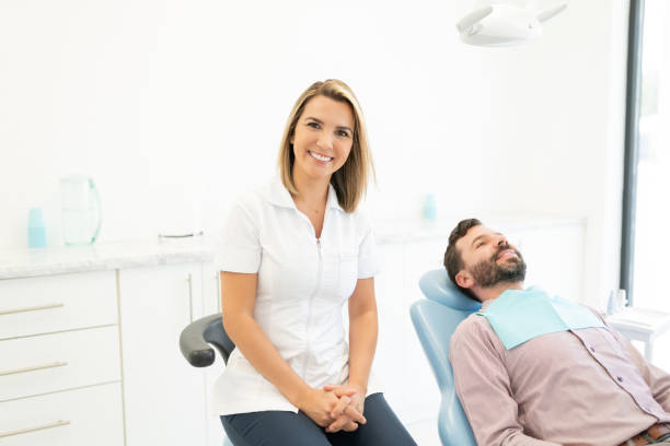istock Smiling Orthodontist By Patient On Chair 1256361821