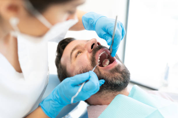 istock Dentist Checking Teeth Of Mid Adult Man 1256362804